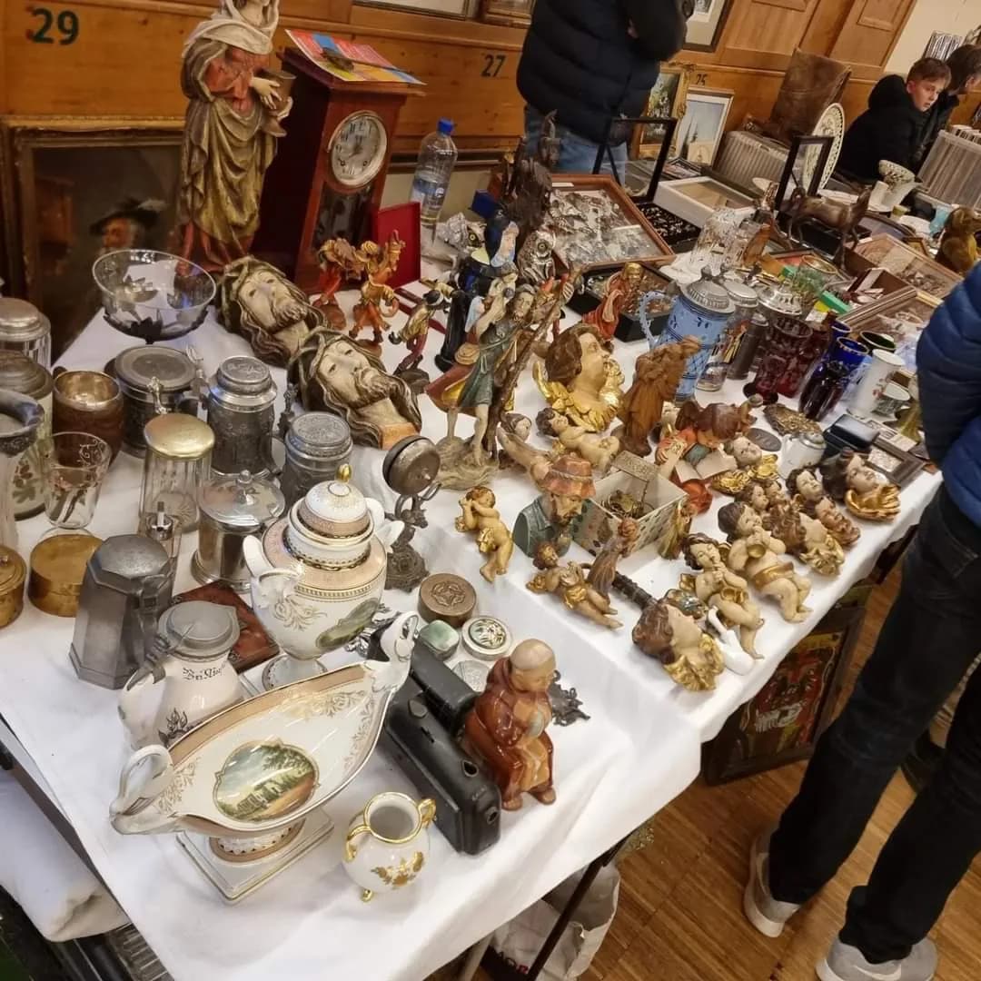 Antikstand mit Figuren, Krügen und Geschirr auf einem Markt von SR-Märkte